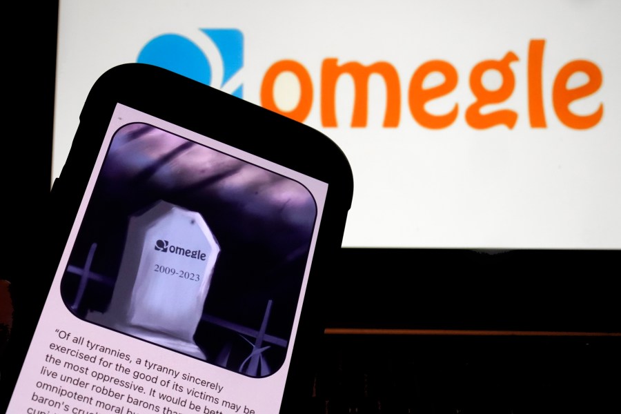 This photo, in New York, Thursday, Nov. 9, 2023, shows the Omegle logo, and their website posting on a mobile phone. Omegle, a video chat service that connects users with strangers at random, is shutting down after 14 years following ample misuse of the platform — particularly the sexual abuse of minors. (AP Photo/Richard Drew)