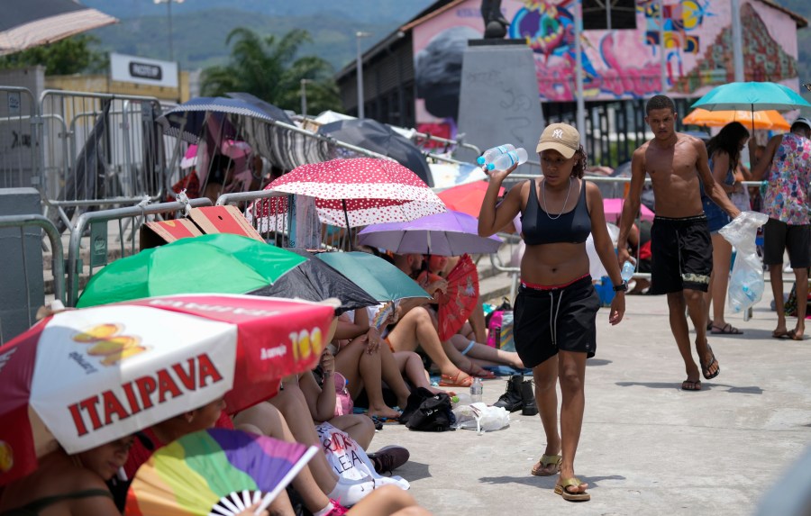 Street vendors sell bottled water to Taylor Swift fans amid a heat wave before her Eras Tour concert outside the Nilton Santos Olympic stadium in Rio de Janeiro, Brazil, Saturday, Nov. 18, 2023. A 23-year-old Taylor Swift fan died at the singer's Eras Tour concert in Rio de Janeiro Friday night, according to a statement from the show's organizers in Brazil. Both Swifties and politicians reacted to the news with outrage. While a cause of death for Ana Clara Benevides Machado has not been announced, fans complained they were not allowed to take water into Nilton Santos Olympic Stadium despite soaring temperatures. (AP Photo/Silvia Izquierdo)