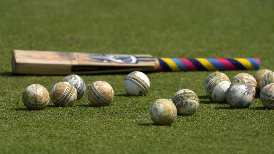 FILE -Cricket balls and a bat is seen on the ground before the start of ICC Men's Cricket World Cup match between New Zealand and South Africa in Pune, India, Wednesday, Nov.1, 2023. Transgender women will not be allowed to compete in international women’s cricket. The International Cricket Council (ICC) said the “new gender eligibility regulation” had been imposed to protect the integrity of women’s cricket and was also made on safety grounds. (AP Photo/Manish Swarup, File)