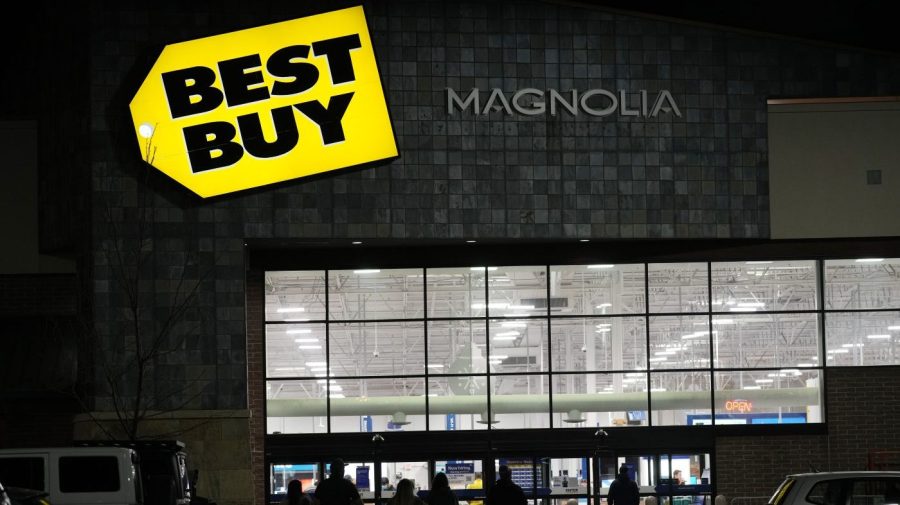 FILE - Shoppers are silhouetted as they walk toward a Best Buy store after doors opened at 5 a.m., Nov. 26, 2021, in Lone Tree, Colo. Best Buy Co. posted stronger-than-expected profits, Tuesday, Nov. 21, 2023, but reported a drop in revenue for the fiscal third quarter as shoppers continue to pull back on buying gadgets in an uncertain economy. (AP Photo/David Zalubowski, file)