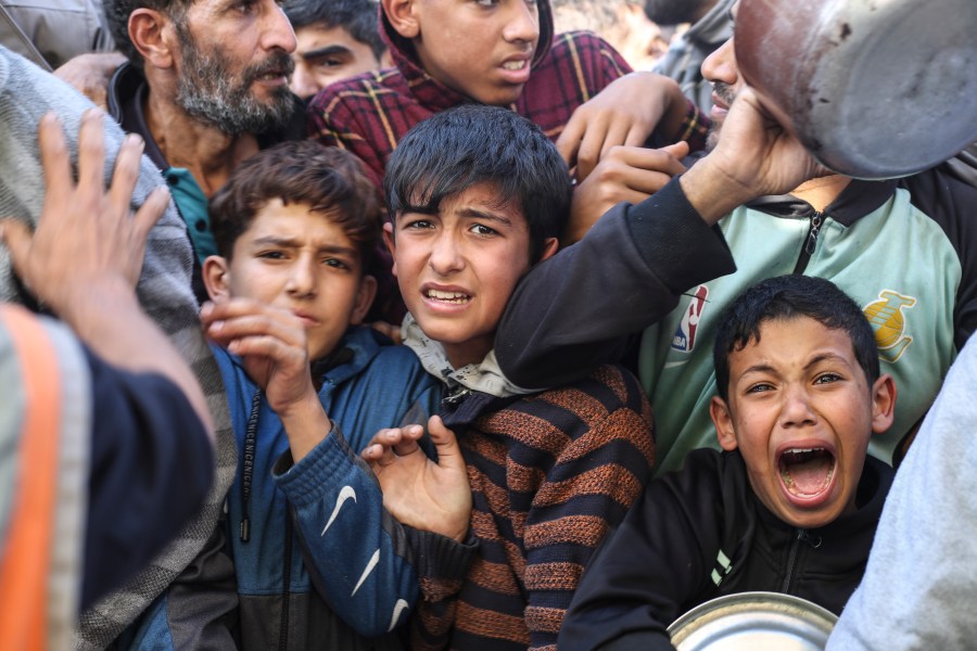 Palestinians line up for food in Rafah, Gaza Strip, Thursday, Nov. 30, 2023, during a temporary ceasefire between Israel and Hamas. (AP Photo/Hatem Ali)