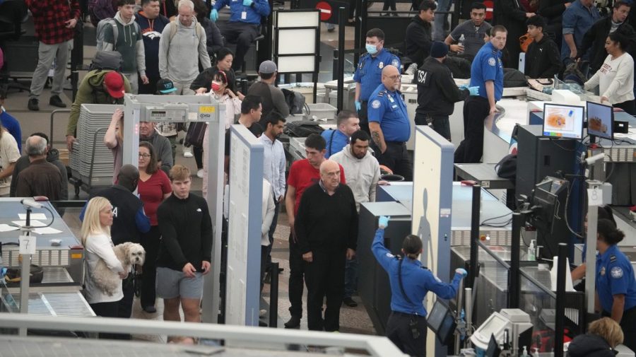 Travelers queue up to pass through an airport security checkpoint.