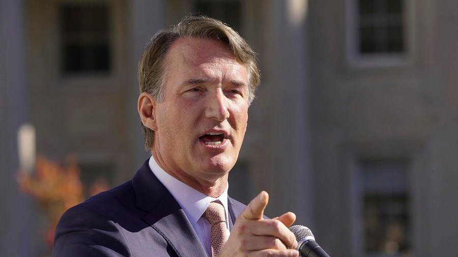 Virginia Governor Glenn Youngkin gestures while speaking at an event.