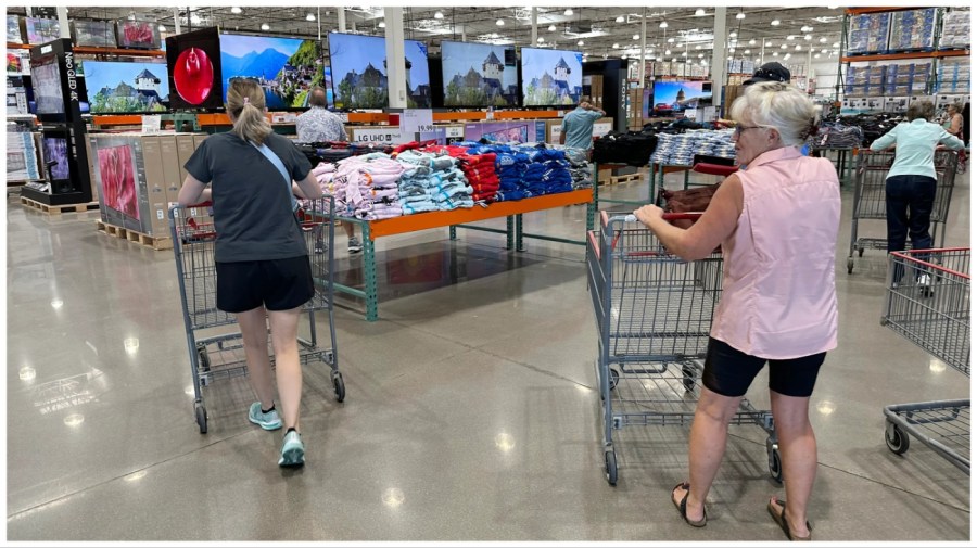 File - Shoppers push carts into a Costco warehouse Friday, Aug. 4, 2023, in Thornton, Colo. A surge in U.S. consumer spending is fueling economic growth, reflecting a resilience among households that has confounded economists, Federal Reserve officials and even the sentiments that Americans themselves have expressed in surveys.(AP Photo/David Zalubowski, File)