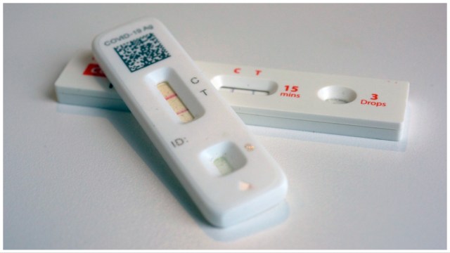 Two COVID-19 antigen home tests indicate a positive result.