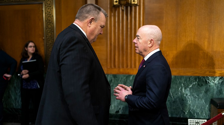 Sen. Jon Tester (D-Mont.) speaks with Secretary of Homeland Security Alejandro Mayorkas