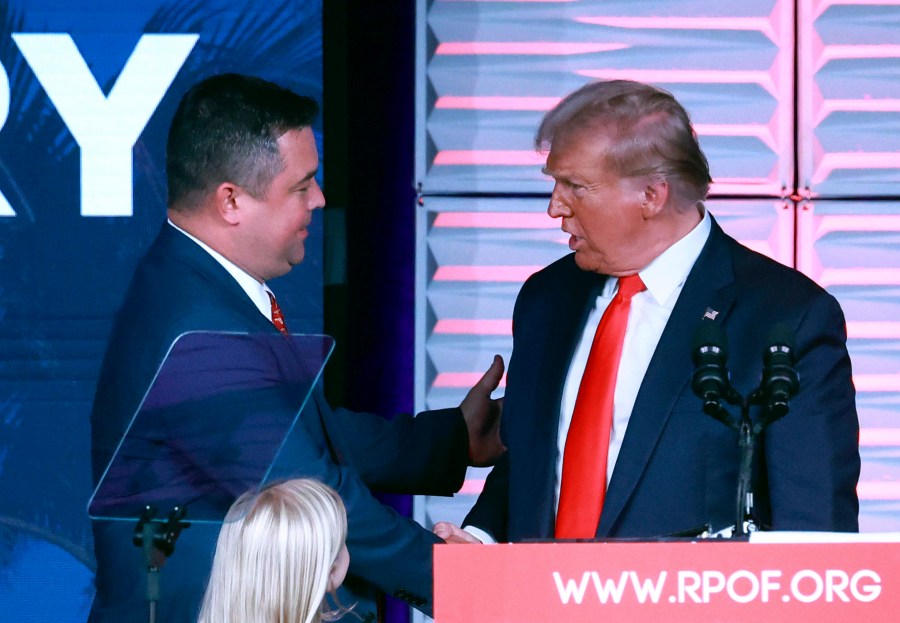 Republican Party of Florida chairman Christian Ziegler, left, greets former president Donald Trump at the RPOF Freedom Summit on Nov. 4, 2023, in Kissimmee, Fla. Ziegler is the subject of a rape investigation, though no charges have been filed and police are providing little information on the accusation. (Joe Burbank/Orlando Sentinel via AP)