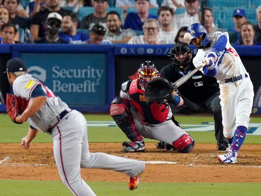 FILE - Los Angeles Dodgers' Mookie Betts, right, hits a solo home run as Atlanta Braves relief pitcher Joe Jimenez, left, watches along with catcher Sean Murphy, second from left, and home plate umpire Dan Bellino, second from right, during the seventh inning of a baseball game Aug. 31, 2023, in Los Angeles.