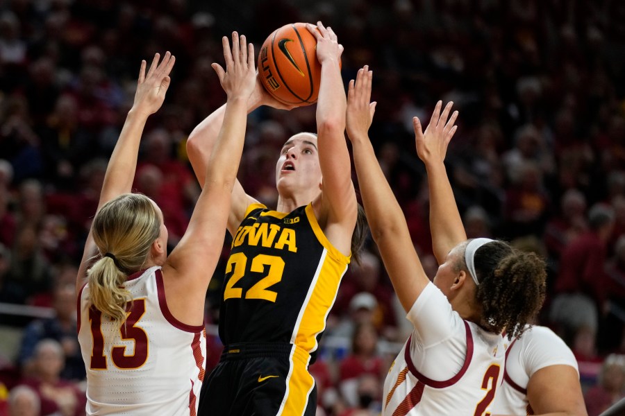 Iowa guard Caitlin Clark (22) shoots between Iowa State guard Hannah Belanger (13) and guard Arianna Jackson (2) during the first half of an NCAA college basketball game, Wednesday, Dec. 6, 2023, in Ames, Iowa. (AP Photo/Charlie Neibergall)