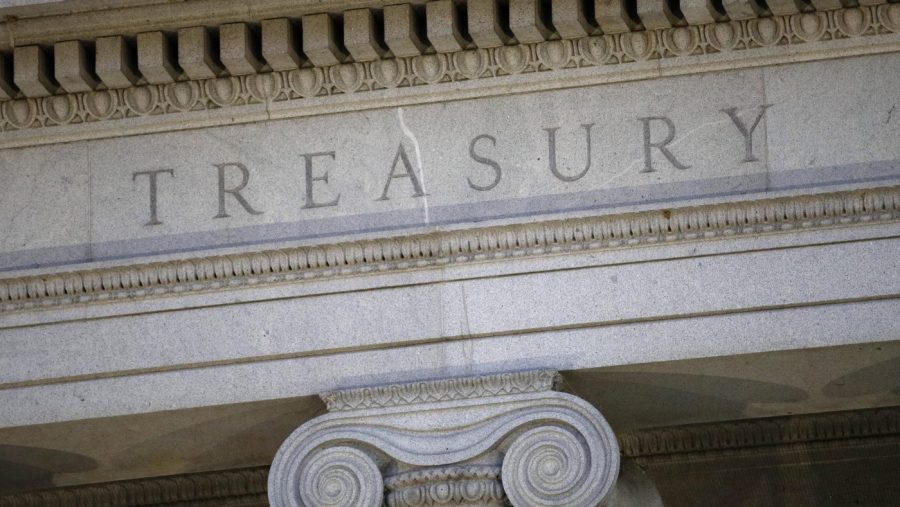 The U.S. Treasury Department building is shown at dusk.