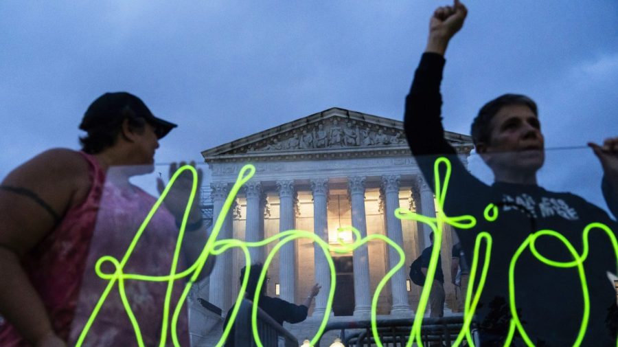 FILE - Activists mark the first anniversary of the Supreme Court's decision in Dobbs v. Jackson Women's Health Organization by displaying neon signage in support of abortion access, June 23, 2023, in Washington. Ever since the nation’s highest court ended abortion rights more than a year ago by overturning Roe v. Wade, vaguely worded bans enacted in some Republican-controlled states have caused bewilderment over how exceptions should be applied. (AP Photo/Nathan Howard, File)