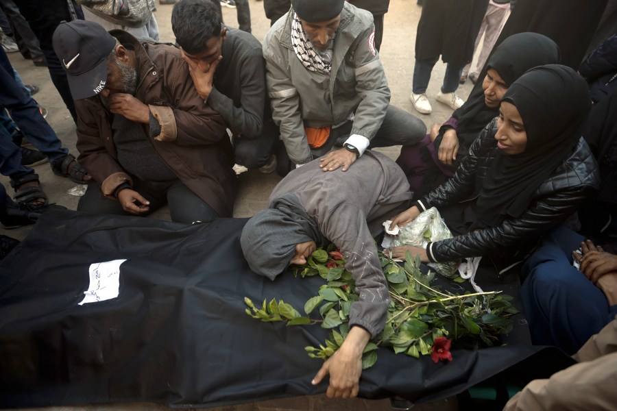 Palestinians mourn relatives killed in the Israeli bombardment of the Gaza Strip outside a morgue in Khan Younis on Sunday, Dec. 24, 2023. (AP Photo/Mohammed Dahman)