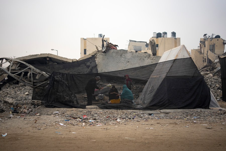 Palestinians displaced by the Israeli bombardment of the Gaza Strip cook at the makeshift tent camp in the Muwasi area on Thursday, Dec. 28, 2023. (AP Photo/Fatima Shbair)