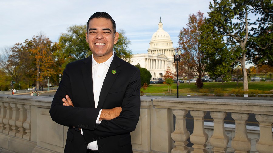 Representative Robert Garcia smiles for a photo with the Capitol in the background.