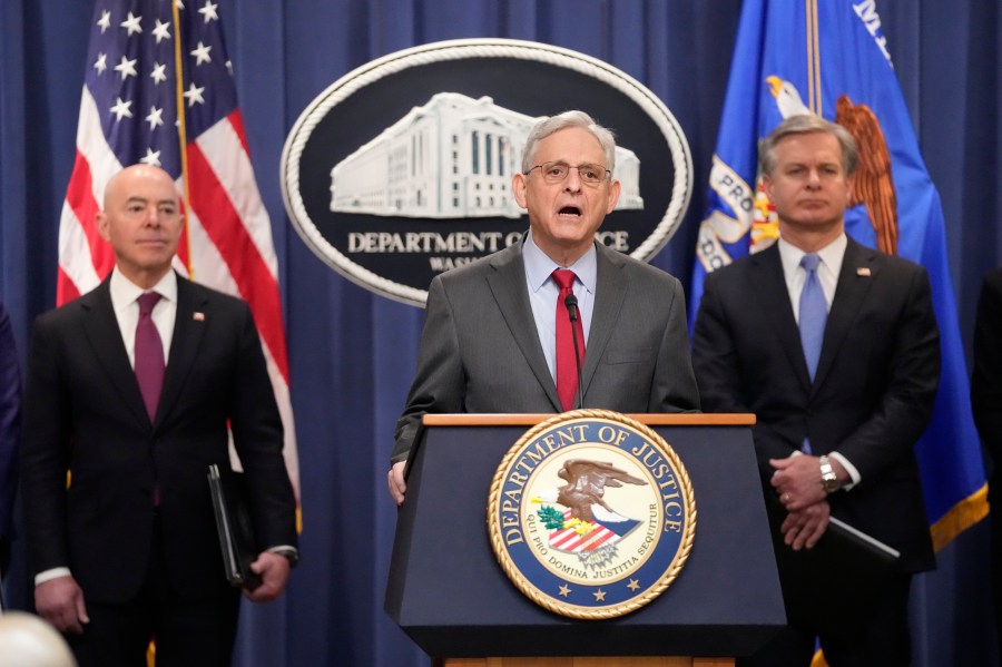 Attorney General Merrick Garland speaks with reporters during a news conference at the Department of Justice, Wednesday, Dec. 6, 2023, in Washington, as Secretary of Homeland Security Alejandro Mayorkas, left, and FBI Director Christopher Wray, looks on. (AP Photo/Mark Schiefelbein)