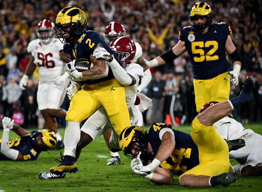 FILE - Michigan running back Blake Corum (2) runs in for a touchdown past Alabama defensive back Kool-Aid McKinstry (1) during overtime at the Rose Bowl CFP NCAA semifinal college football game Jan. 1, 2024, in Pasadena, Calif.