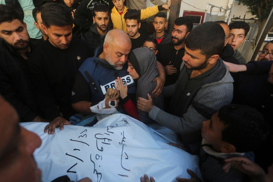 Al Jazeera journalist Wael Dahdouh holds the hand of his son Hamza, who also worked for Al Jazeera and who was killed in an Israeli airstrike in Rafah, Gaza Strip, Sunday, Jan. 7, 2024. Dahdouh lost his wife, two other children and a grandson earlier in the war and was nearly killed himself. (AP Photo/Hatem Ali)