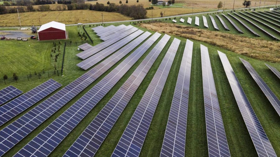 FILE - Farmland is seen with solar panels from Cypress Creek Renewables, Oct. 28, 2021, in Thurmont, Md. A new report says climate-altering pollution from greenhouse gases declined by nearly 2% in the United States in 2023, even as the economy expanded at a faster clip. The report from the Rhodium Group said the decline is a step in the right direction but far below the rate needed to meet President Joe Biden's pledge to cut U.S. emissions in half by 2030. (AP Photo/Julio Cortez, File)