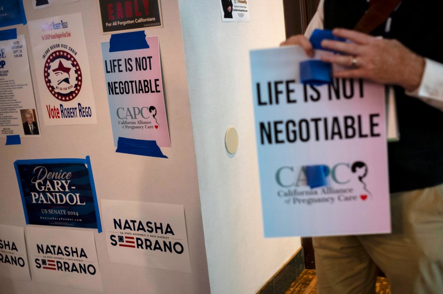 FILE - An Anti-abortion supporter holds a sign at the California Republican Party Convention in Anaheim, Calif., Sept. 30, 2023. In a new twist to the abortion debate, congressional Republicans are trying to block a Biden administration spending rule that they say will cut off millions of dollars to anti-abortion counseling centers. The rule would prohibit states from sending federal funds earmarked for needy Americans to so-called "crisis pregnancy centers," which counsel against abortions.(AP Photo/Jae C. Hong, File)