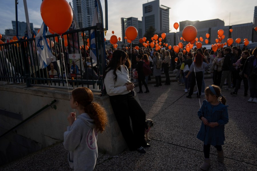 Demonstrators hold orange balloons at a rally in solidarity with Kfir Bibas, an Israeli boy who spent his first birthday Thursday in Hamas captivity in the Gaza Strip, in Tel Aviv, Israel, Thursday, Jan. 18, 2024. The plight of Bibas, the youngest hostage held by Hamas, has captured the nation's attention and drawn attention to the government's failure to bring home more than 100 hostages still held by Hamas after more than three months of war. (AP Photo/Oded Balilty)