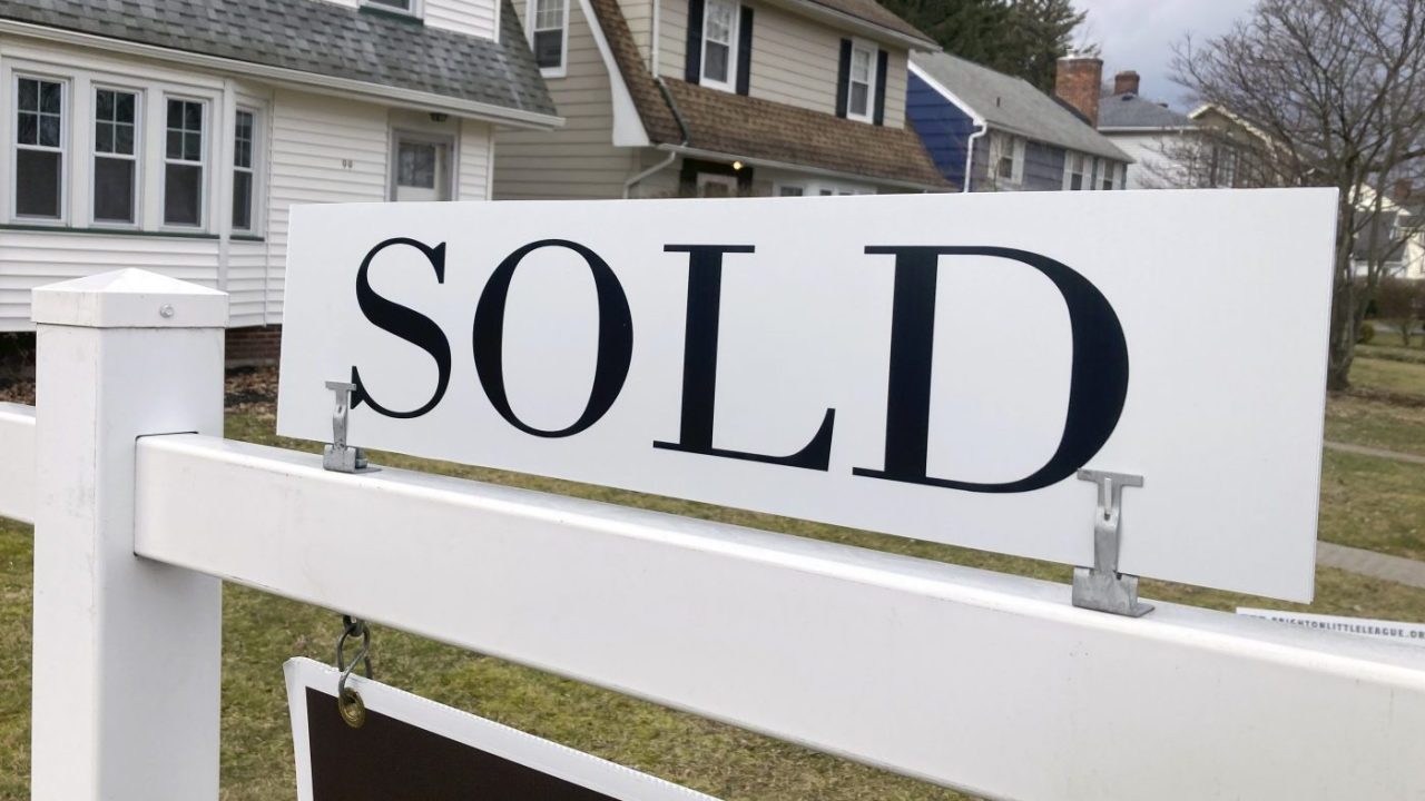 A sold sign is shown in front of a house.