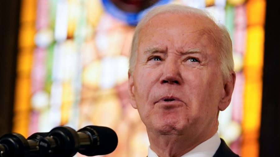 President Biden speaks against a backdrop of stained glass.