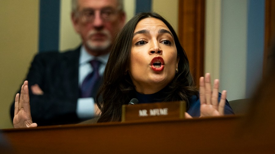 Representative Alexandria Ocasio-Cortez gestures while speaking at a committee markup.