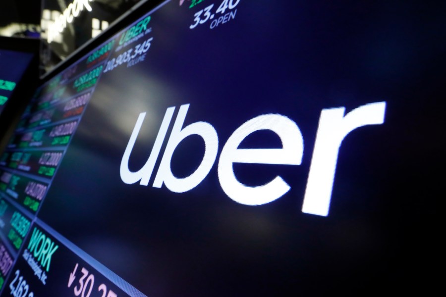 FILE - The Uber logo appears above a trading post on the floor of the New York Stock Exchange, Aug. 16, 2019. Uber posted its first full-year profit since going public in 2019 and its stock hit an all-time high Wednesday, Feb. 7, 2024, as strong bookings in the final quarter of the year pushed profit and revenue beyond Wall Street expectations. (AP Photo/Richard Drew, File)