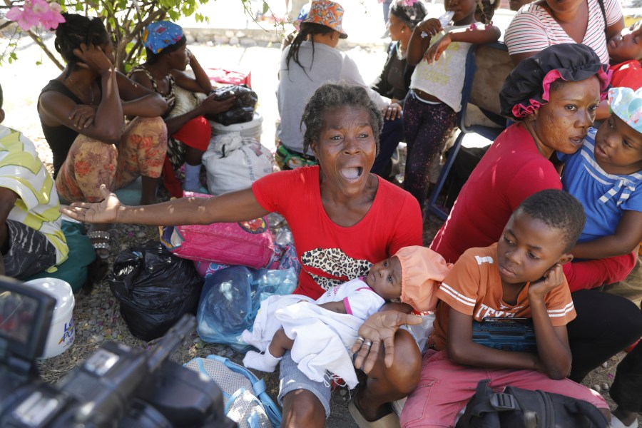 Women and children gather outside a police station after fleeing their homes in Cite Soleil due to gang violence, in Port-au-Prince, Haiti, Monday, Feb. 12, 2024. (AP Photo/Odelyn Joseph)