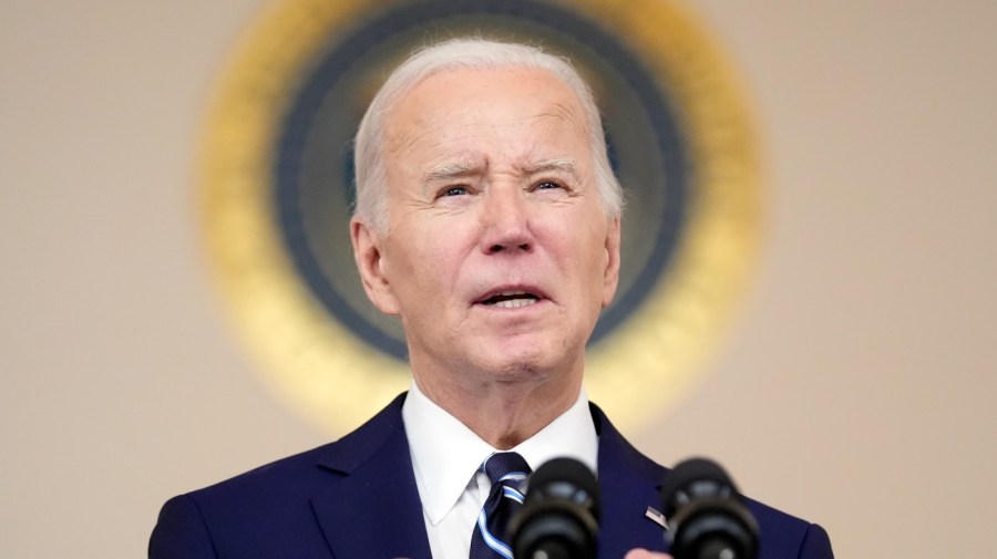 President Biden speaks into a microphone.