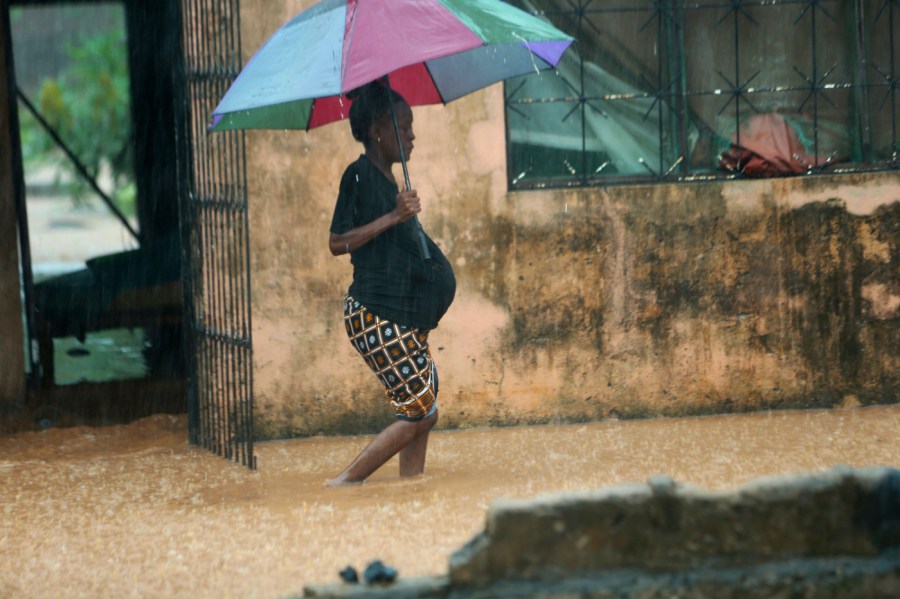 A pregnant woman makes her way out of her flooded home in Natite neighbourhood, in Pemba city on the northeastern coast of Mozambique, Sunday, April, 28, 2019.