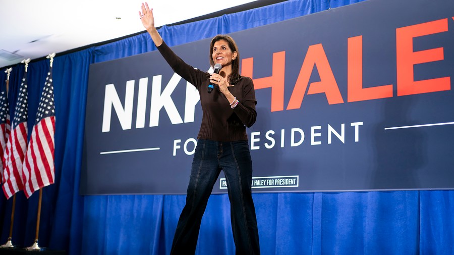 Republican presidential candidate Nikki Haley waves while on stage at a campaign event.