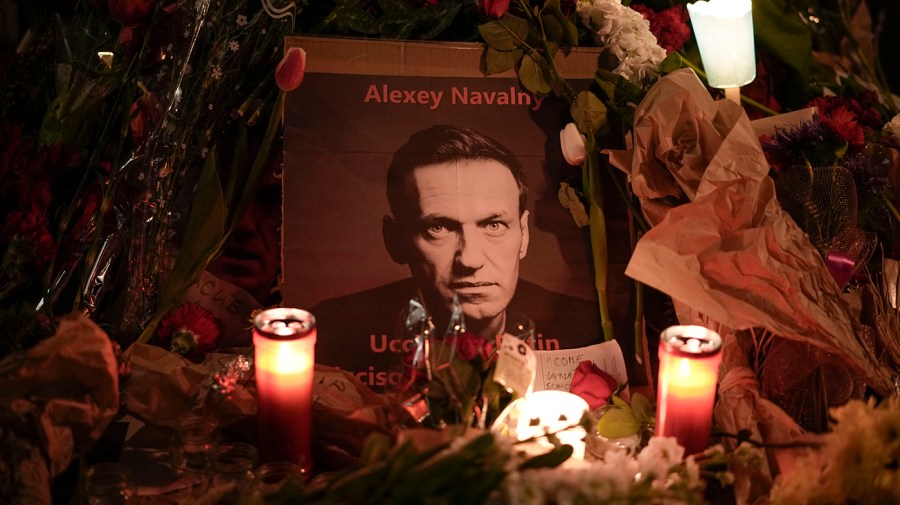 Flowers and candles are laid around a photo of Russian opposition leader Alexei Navalny as a memorial.