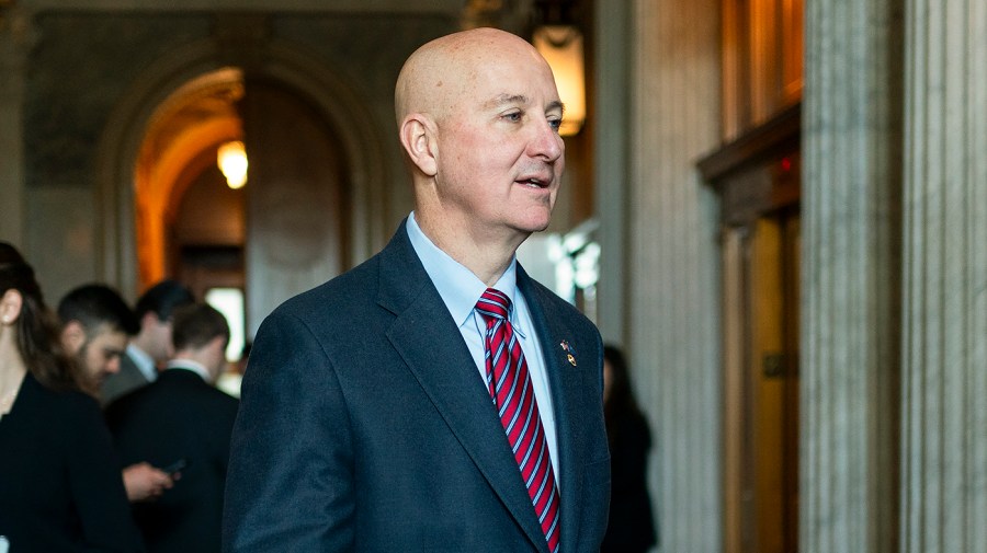 Senator Pete Ricketts walks in the Capitol.