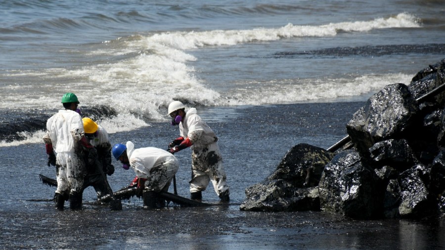 Workers from state own Heritage Petroleum Oil and Gas Company clean up an oil spill that reached Rockly Bay beach, in Scarborough, south western Tobago, Trinidad and Tobago, Sunday, Feb. 11, 2024.