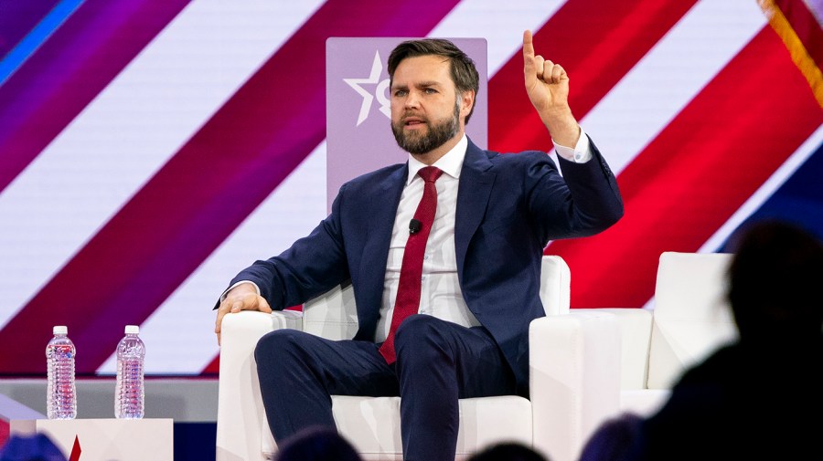 Senator J.D. Vance hold up a hand while being interviewed.