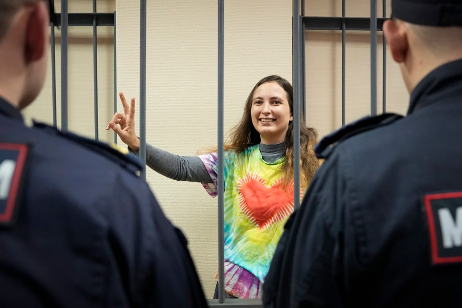 FILE - Sasha Skochilenko, a 33-year-old artist and musician, makes a victory sign standing behind bars in court in St. Petersburg, Russia, Thursday, Nov. 16, 2023, for protesting the conflict in Ukraine. Over the last decade, Vladimir Putin's Russia evolved from a country that tolerates at least some dissent to one that ruthlessly suppresses it. Arrests, trials and long prison terms — once rare — are commonplace. (AP Photo, File)