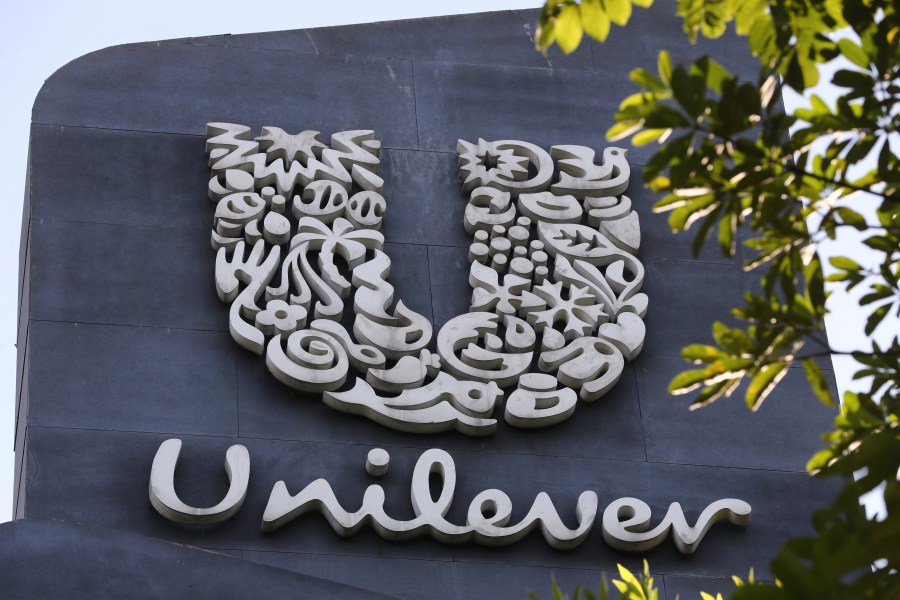 FILE - A Unilever logo is displayed outside the head office of PT Unilever Indonesia Tbk. in Tangerang, Indonesia, Tuesday, Nov. 16, 2021. Unilever, the company that makes Ben & Jerry’s ice cream, Dove soaps and Vaseline, says it's cutting 7,500 jobs and spinning off its ice cream business to reduce costs and boost profits. (AP Photo/Tatan Syuflana, File)