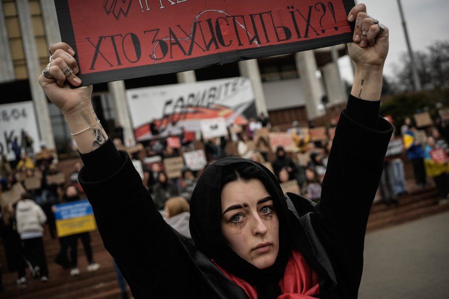 A woman holds a sign during a protest in Kyiv, Ukraine, Sunday March 24, 2024, to demand the freedom of Ukrainian Mariupol's Azovstal defenders still being held prisoners by Russia. (AP Photo/Enric Marti)