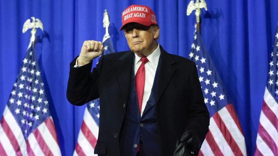 Former President Trump wears a MAGA hat and gestures at a campaign rally.