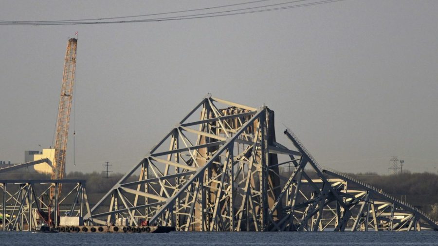 A crane is seen near the wreckage of the Francis Scott Key Bridge.