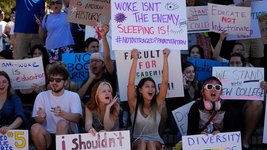 Students hold signs protesting the decision to eliminate the DEI programs at New College in Sarasota, Florida.