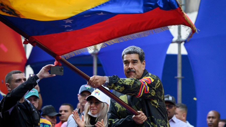 Venezuela's President Nicolas Maduro waves a national flag.