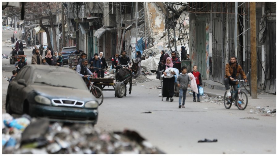 Palestinian residents leave a street with a few items after the Israeli army forces besiege the Al-Shifa hospital with tanks and heavy gunfire in Gaza City.