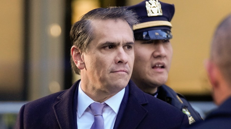 Attorney Todd Blanche arrives at Trump Tower with a police officer in the background.