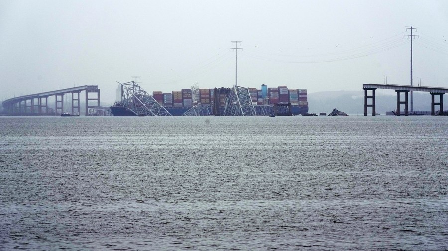 A container ship rests against the wreckage of the Francis Scott Key Bridge.