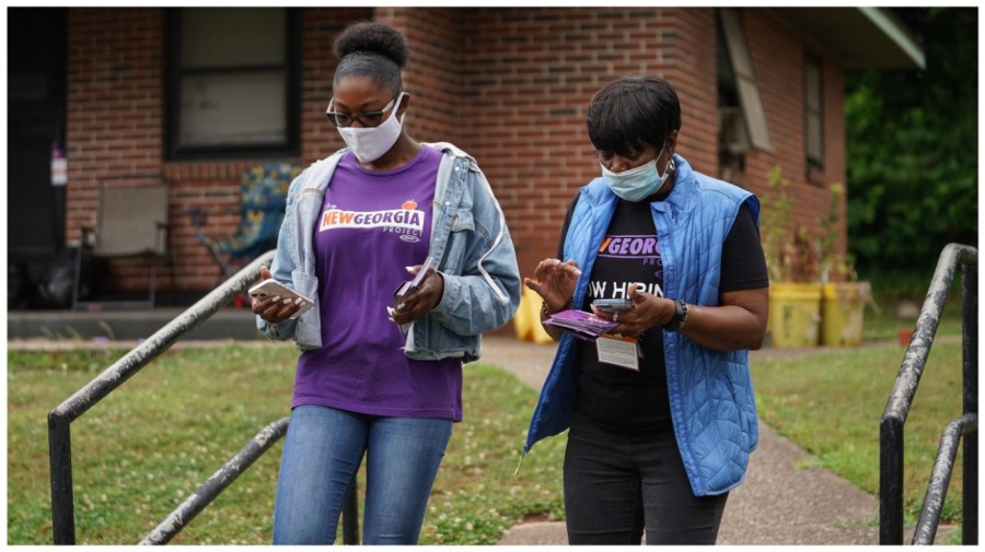 New Georgia Project canvassers Kayla McCall and Mardie Hill (R) go door-to-door to inform residents about the upcoming primary election on May 23, 2022, in East Point, Georgia. (Photo by Elijah Nouvelage /AFP via Getty Images)