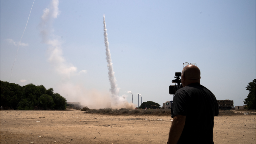 A journalist films Israel's Iron Dome anti-missile system fires to intercept a rocket launched from the Gaza Strip towards Israel, in Ashkelon, Israel, Saturday, Aug. 6, 2022.