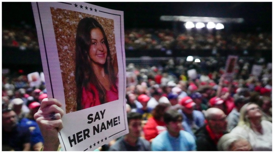 A supporter holds a oster with a photo of Laken Riley before Republican presidential candidate former President Donald Trump speaks at a campaign rally Saturday, March 9, 2024, in Rome Ga. (AP Photo/Mike Stewart)