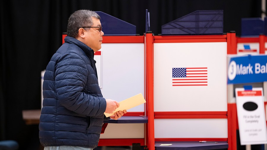 A voter fills out their ballot at the George Mason University’s campus in Arlington, Va.